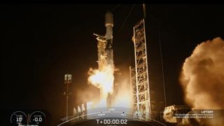 a black-and-white spacex falcon 9 rocket launches into a night sky.