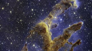 A star-studded image with a large pillar of gas and dust rising through the center.