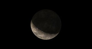 a pock marked richly dark world is a crescent in black sky.